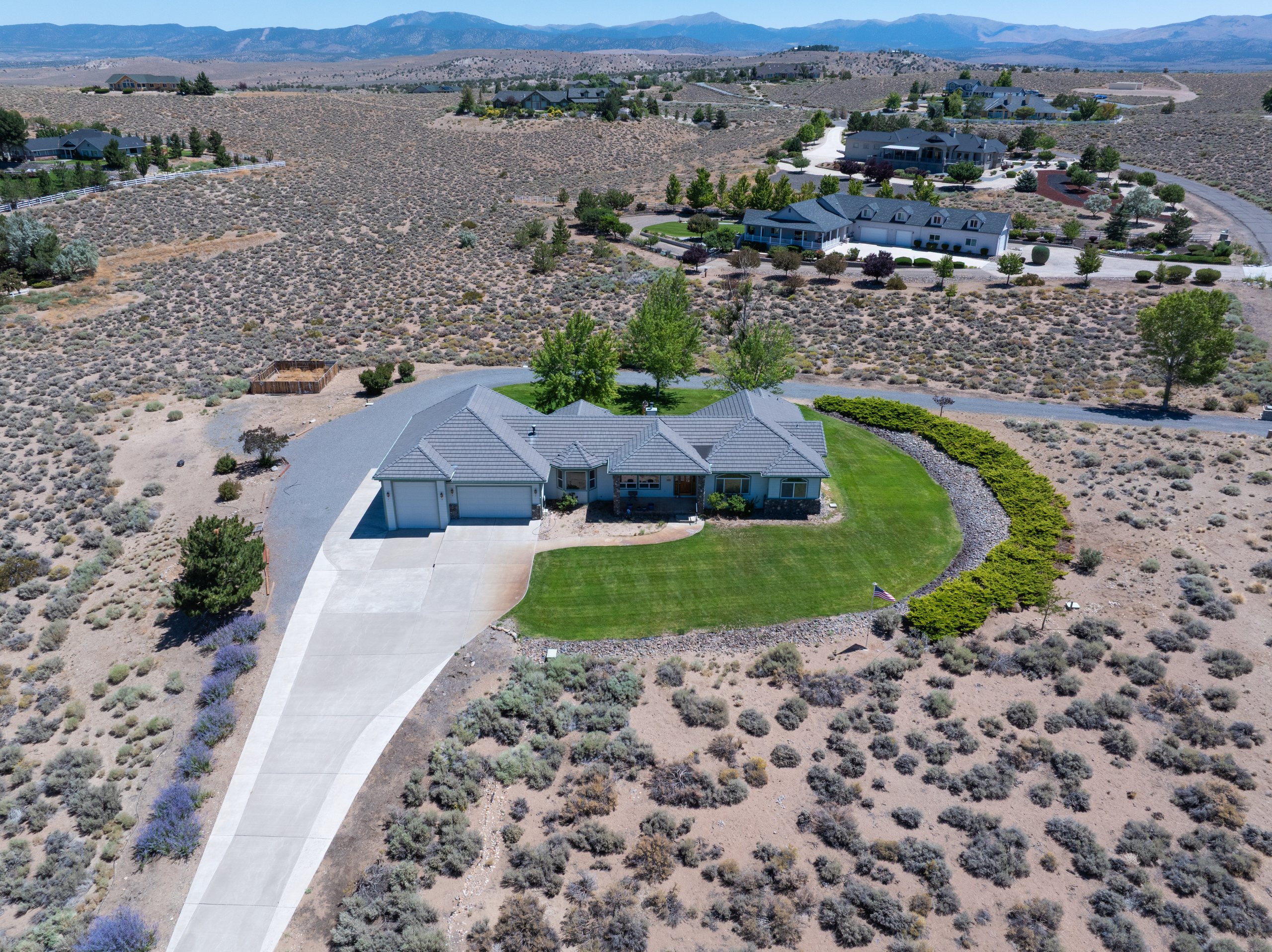 Aerial view of a residence with circular drive and lawn set in open sage, Gardnerville, Nevada